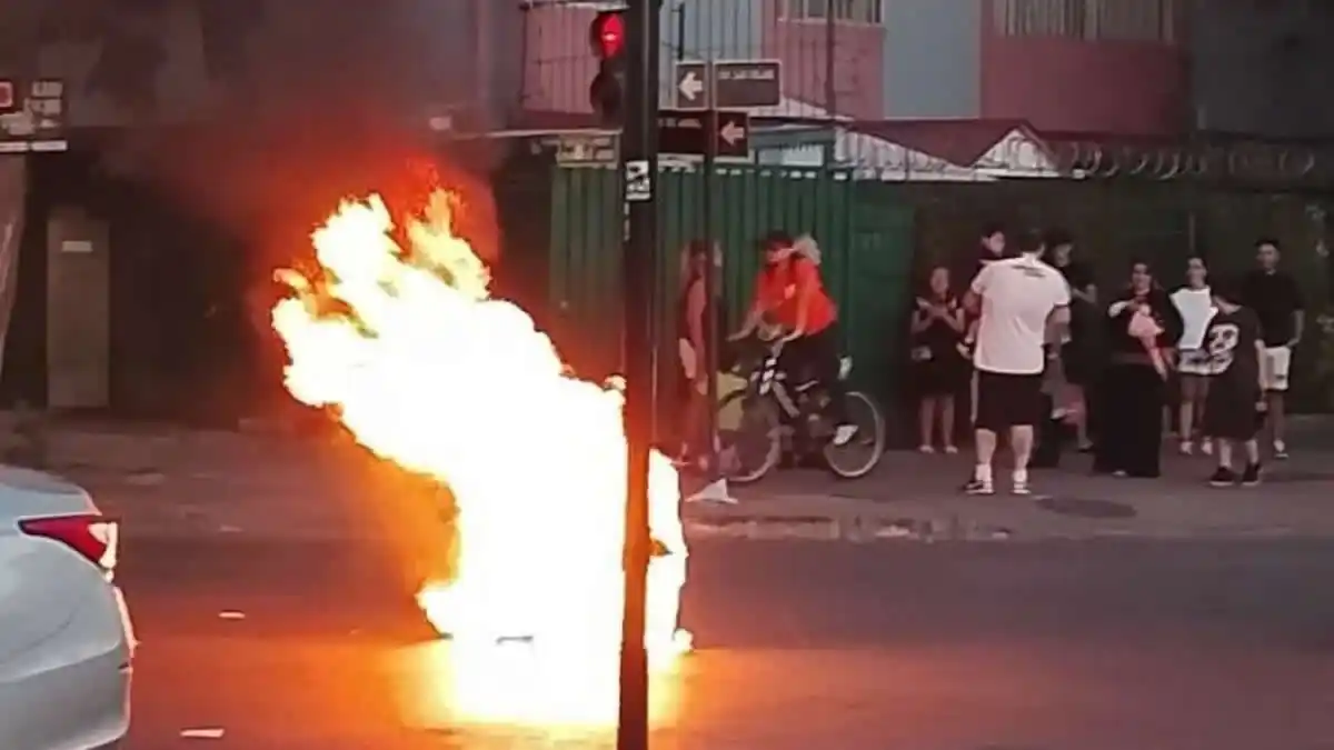 Fuego en la calle, personas observando.