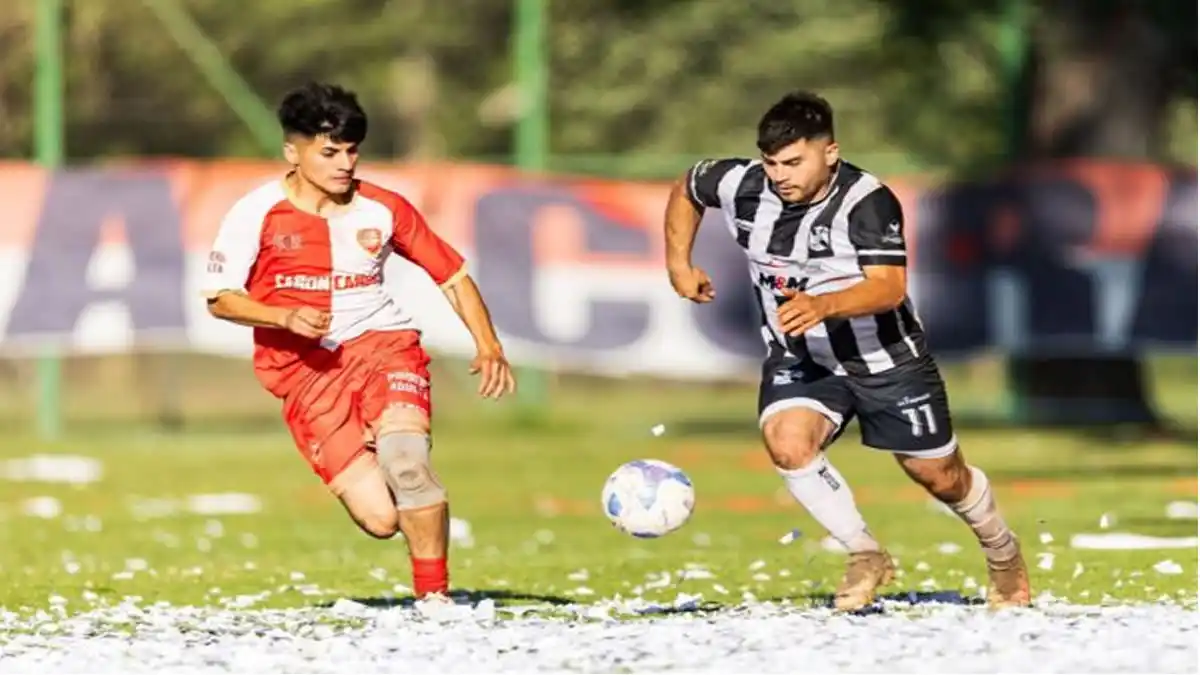 Dos jugadores corriendo tras el balón